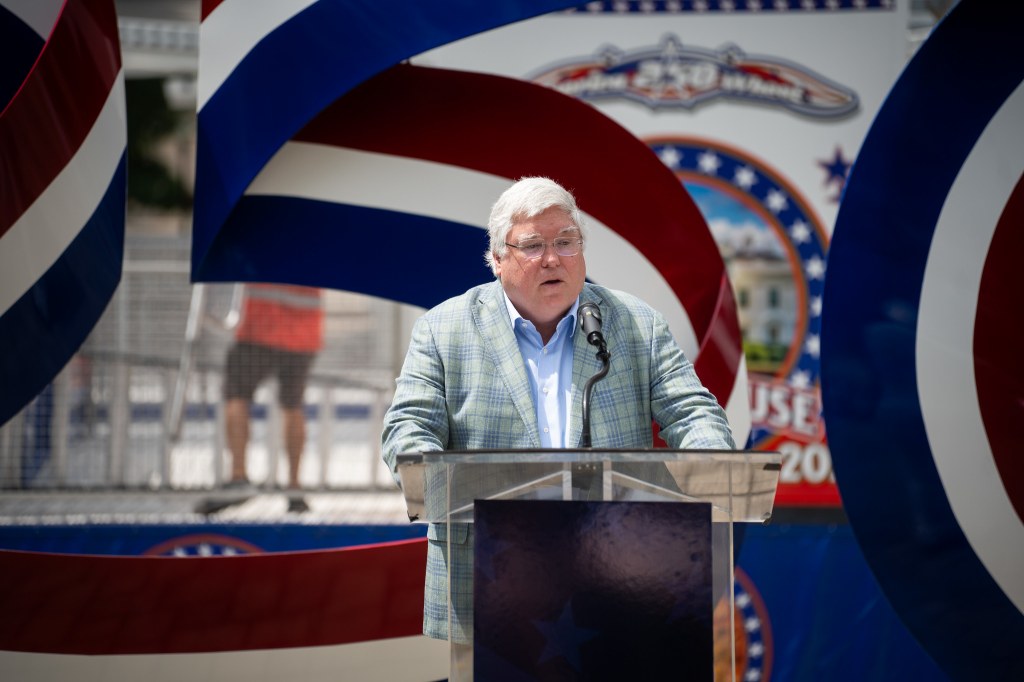 West Virginia Governor Patrick Morrisey speaks with press in front of the America250 Ferris Wheel.