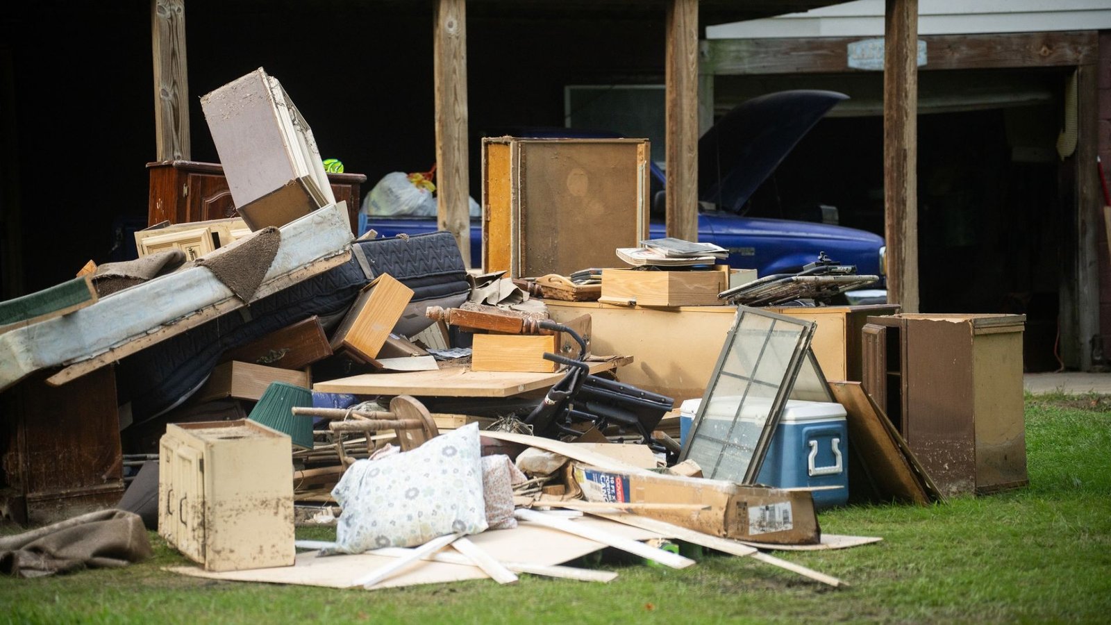 Debris is piled outside a flood-damaged home