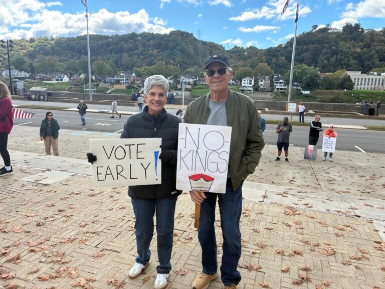 Two rally participants hold signs that reads Vote Early and No Kings
